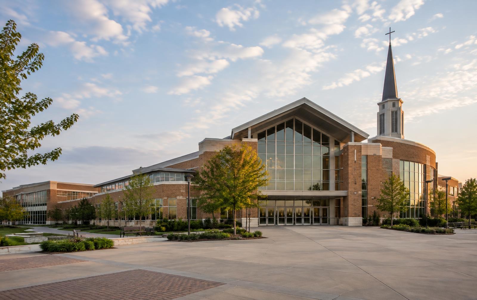 Brick and glass church campus with a steeple and broad entry plaza